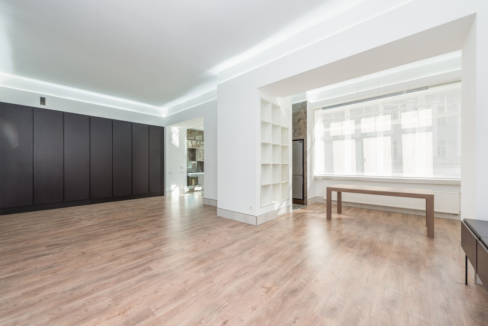 Empty room with built in shelves and light wood floors