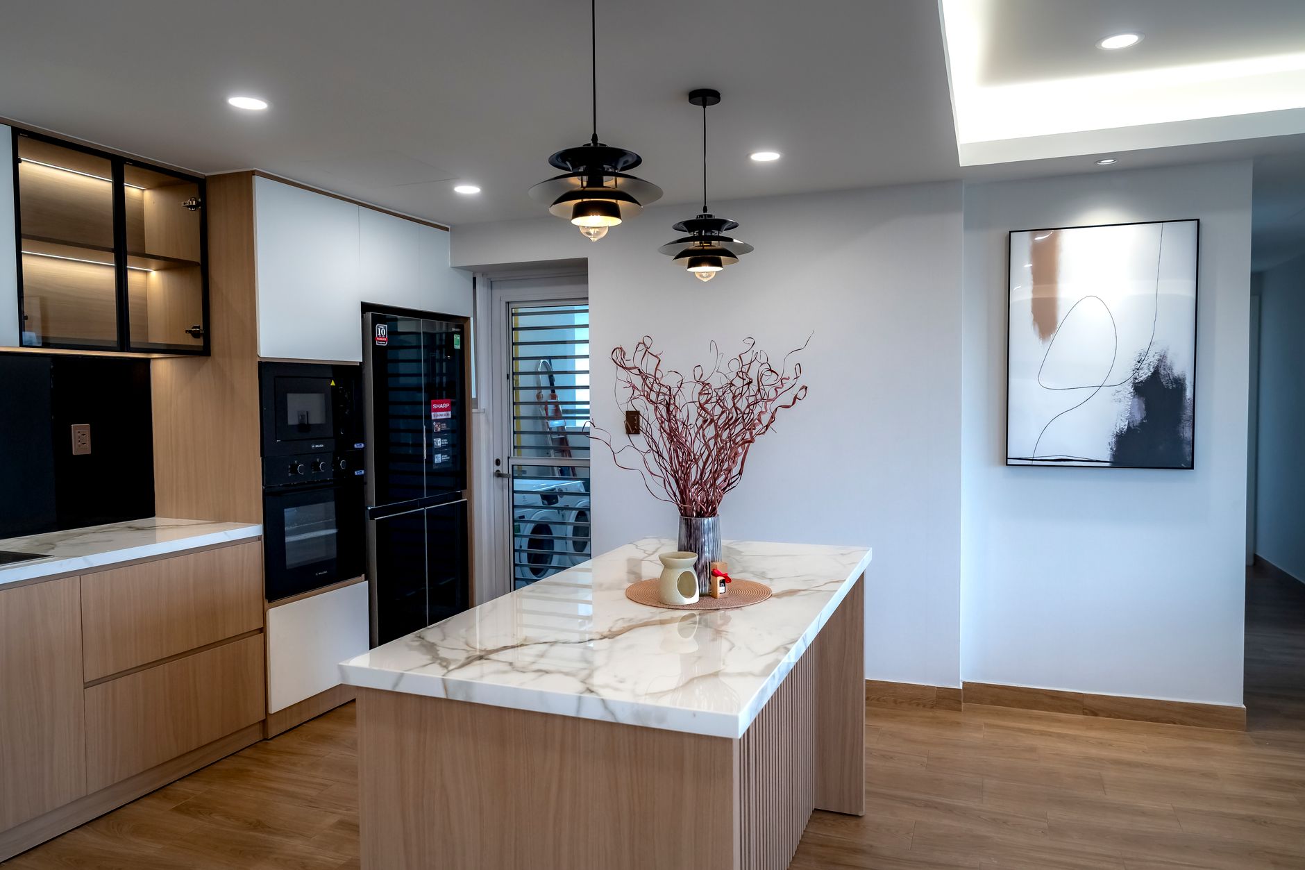 Kitchen with a marble waterfall island and pendant lights