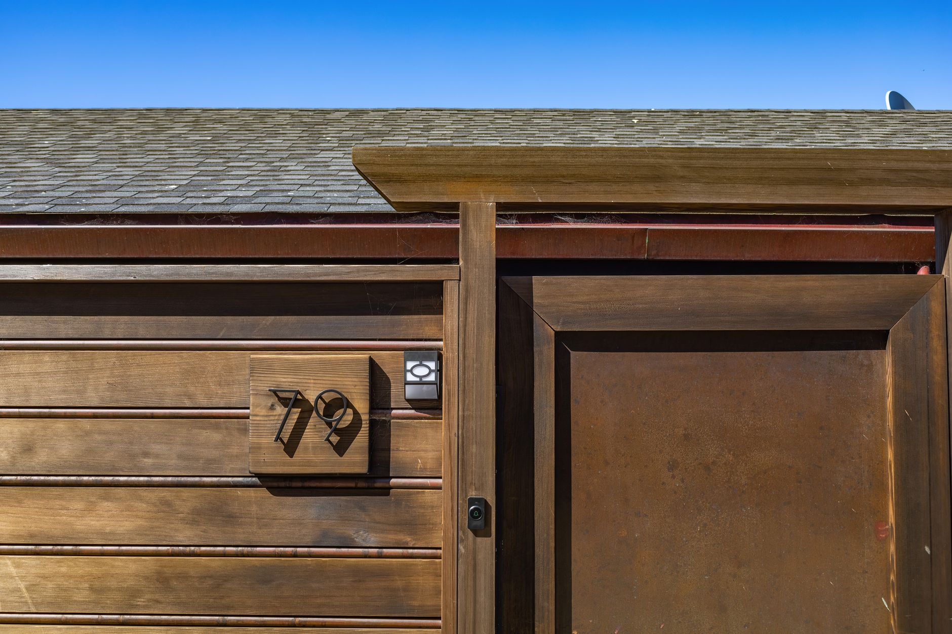 Wood front door with a house number plate