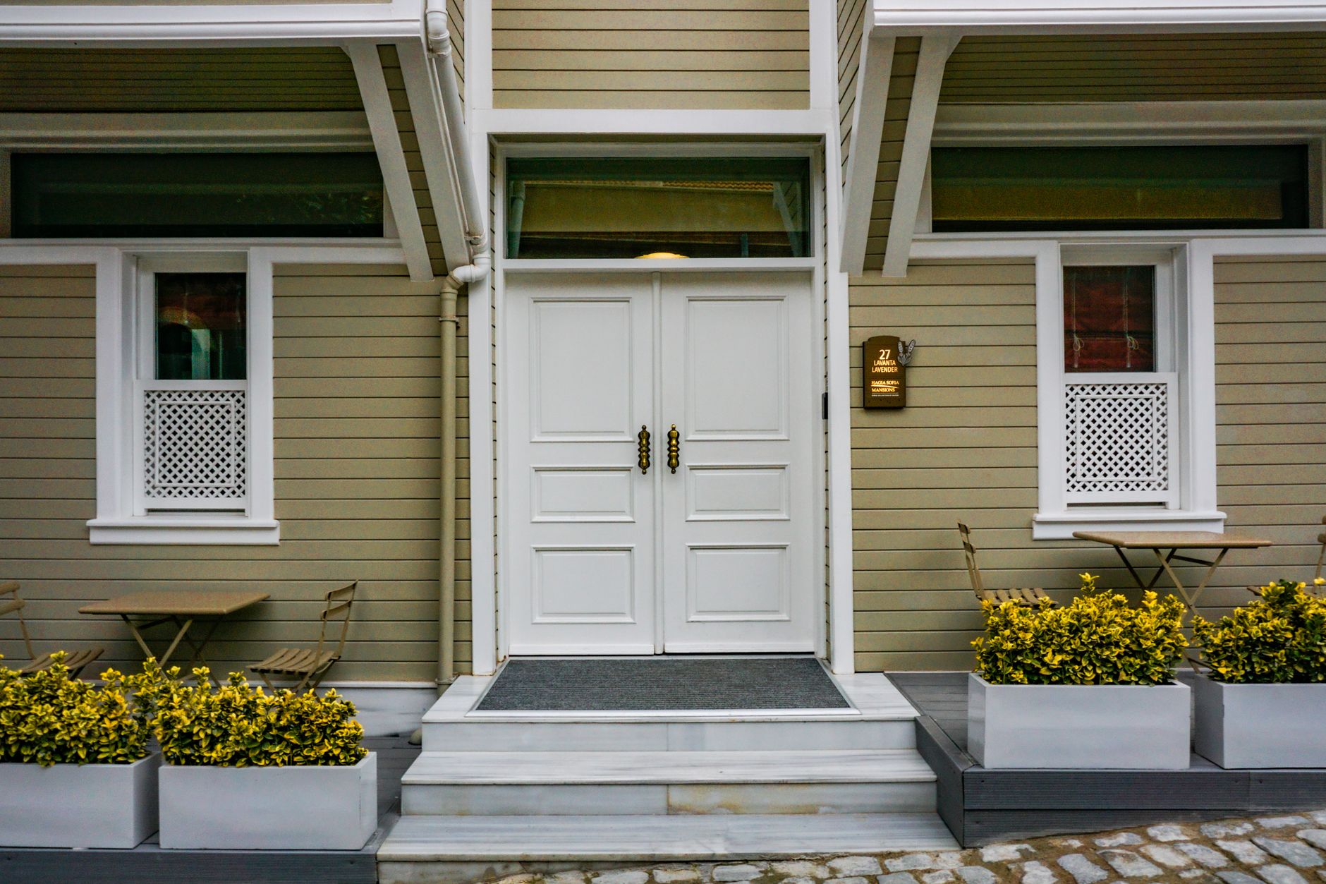 White double front door of a home with planters